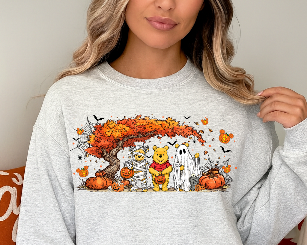 Person wearing a light gray sweatshirt with a Halloween-themed design featuring cartoon characters.