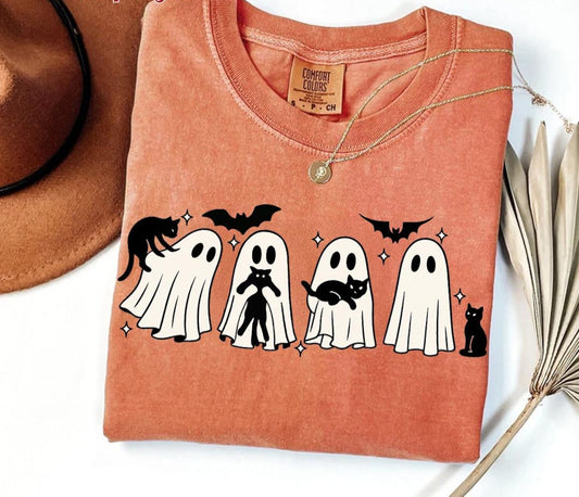 Folded orange t-shirt with Halloween ghost design on a white background