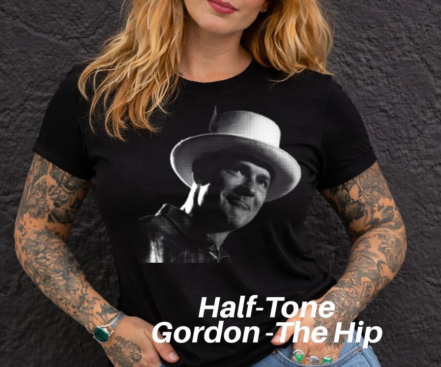 A woman with long blonde hair wearing a black t-shirt with a black and white portrait of a man wearing a hat.