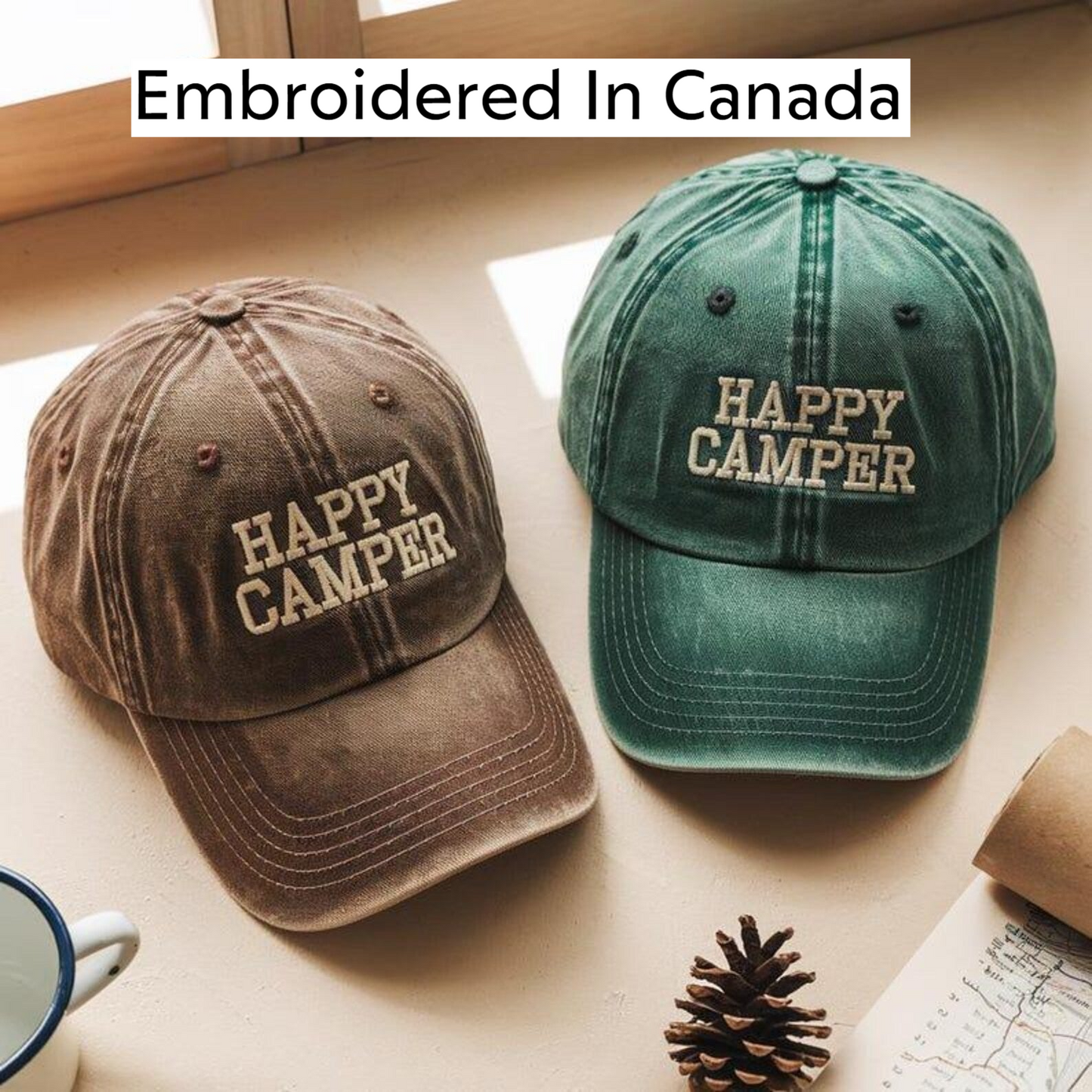 two embroidered hats, one brown and one green, with the word "HAPPY" printed on them. The hats are placed on a table, along with a pine cone and a map.