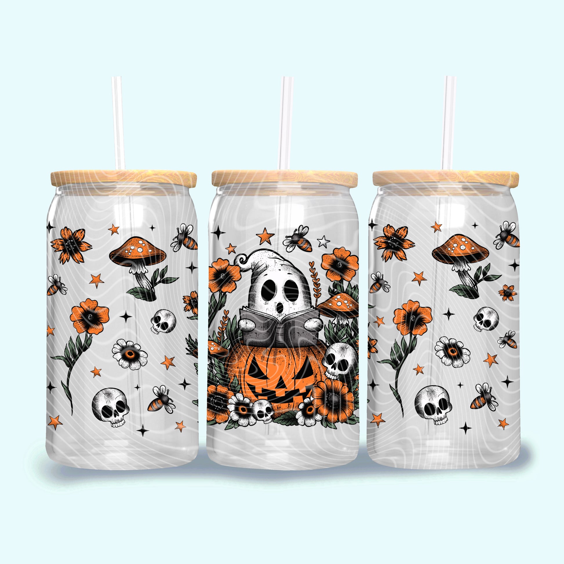 Three Halloween-themed tumblers with wooden lids on a light blue background