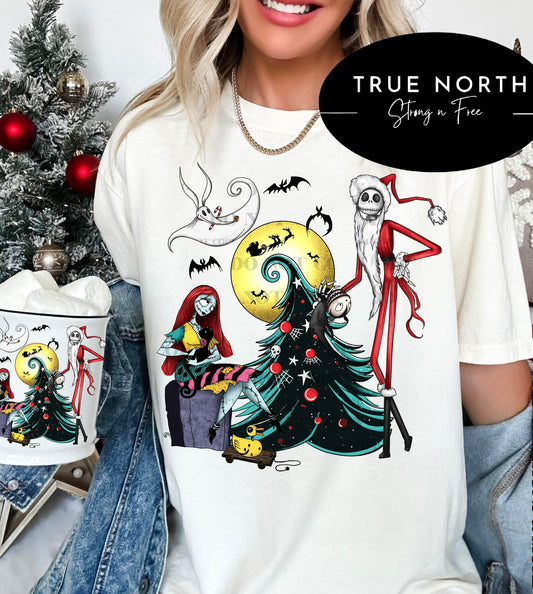 A graphic T-shirt with the 'Nightmare Before Christmas' character theme, displayed in a festive setting with holiday decorations.