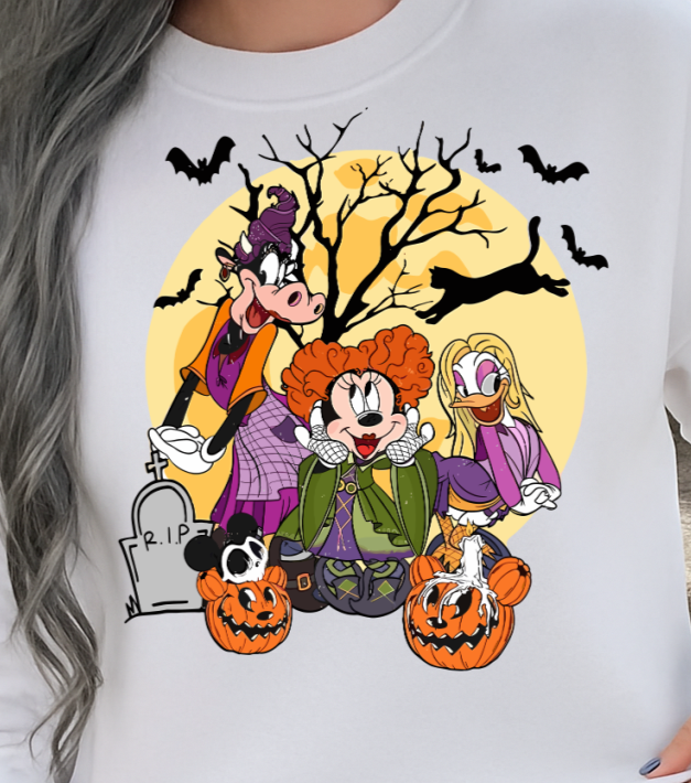 Person wearing a white sweatshirt with Halloween-themed cartoon design, sitting on steps.
