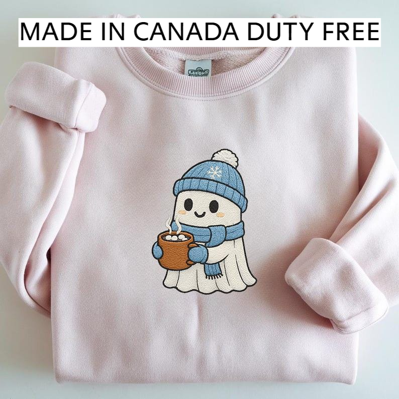 A pink sweater with a cartoon ghost character wearing a blue hat and scarf, holding a mug of hot chocolate, and the text "MADE IN CANADA DUTY FREE" above the sweater.