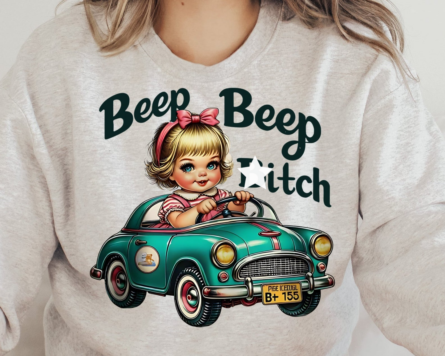 a woman wearing a sweatshirt with a picture of a little girl driving a green car