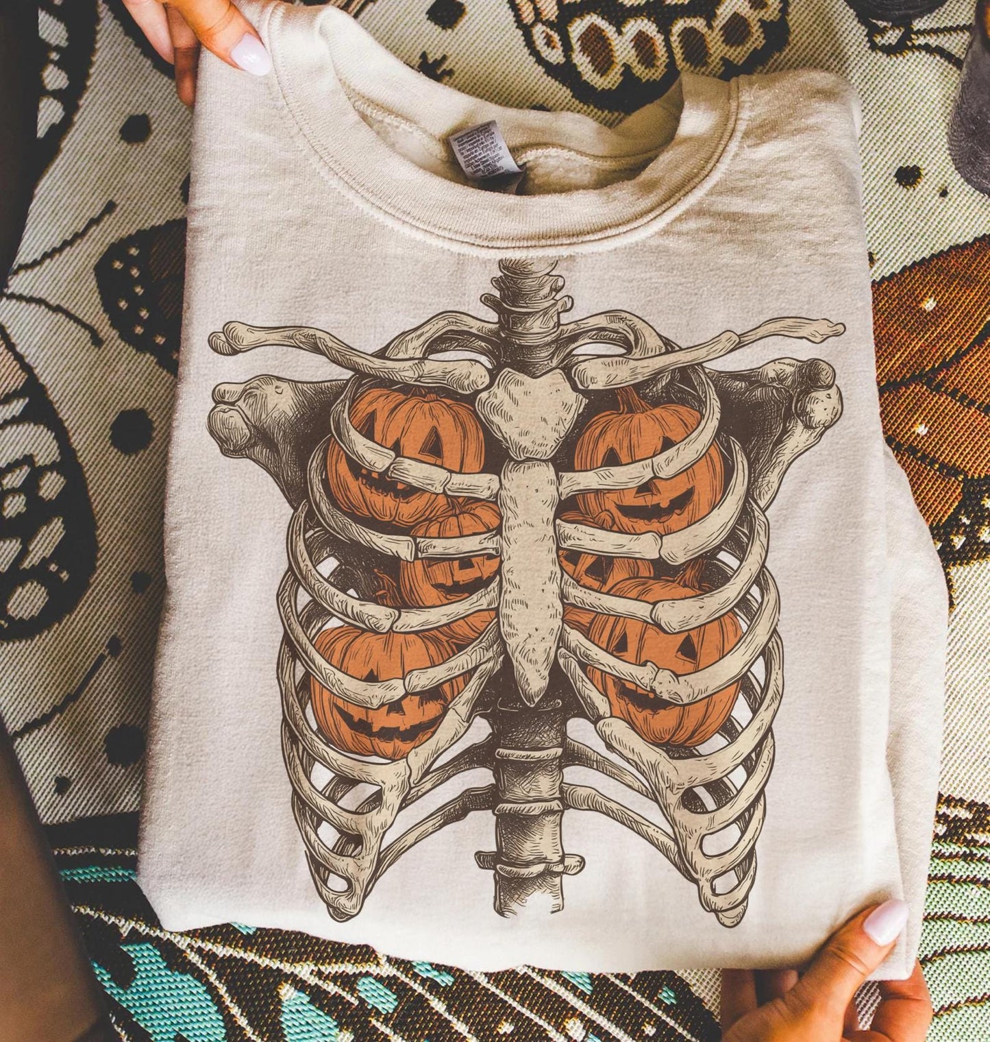 Folded cream sweatshirt with ribcage pumpkins transfer