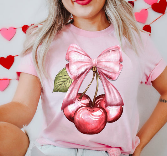 a woman wearing a pink shirt with a cherry on it