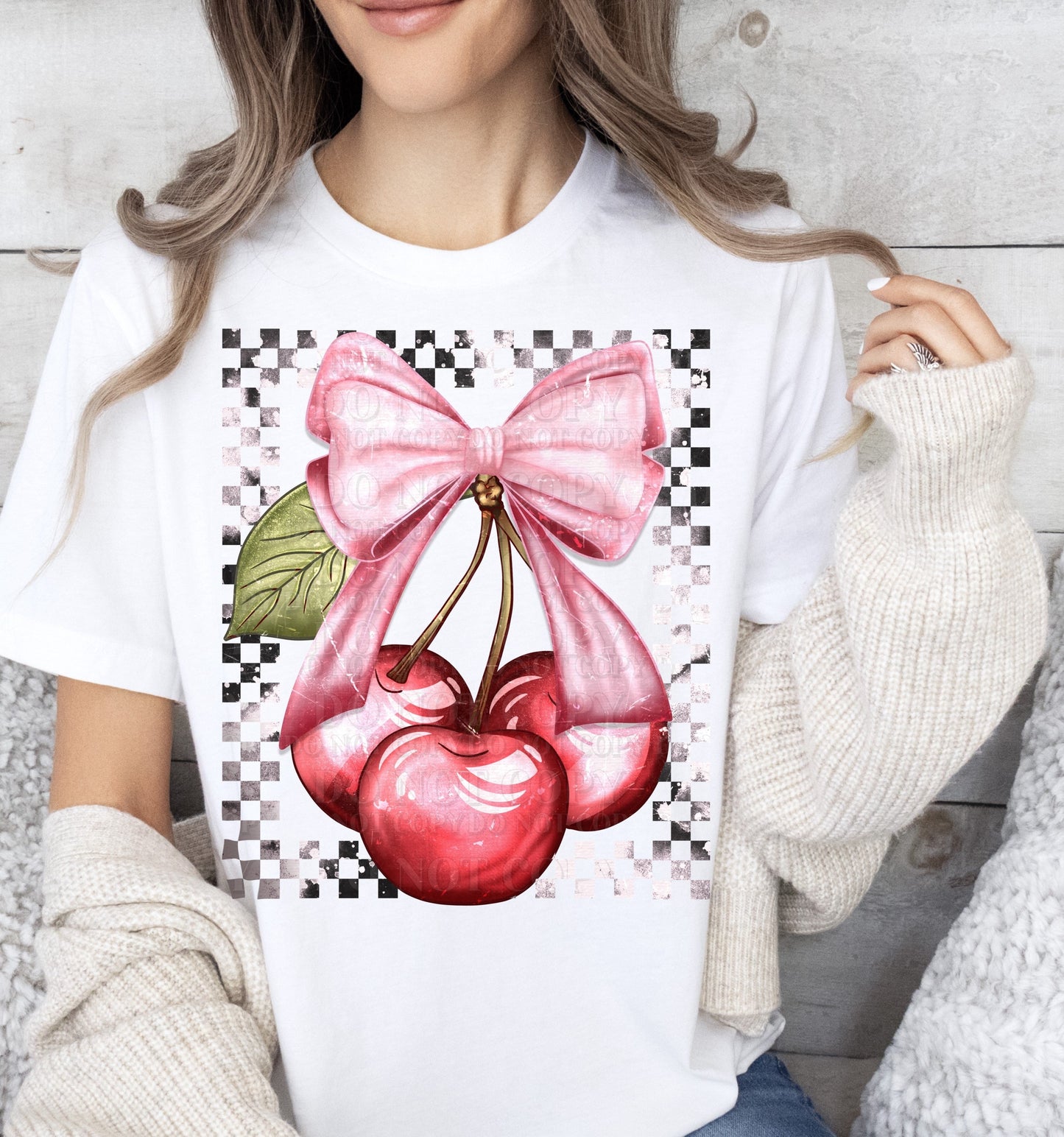 a woman wearing a white shirt with a pink bow and two cherries on it