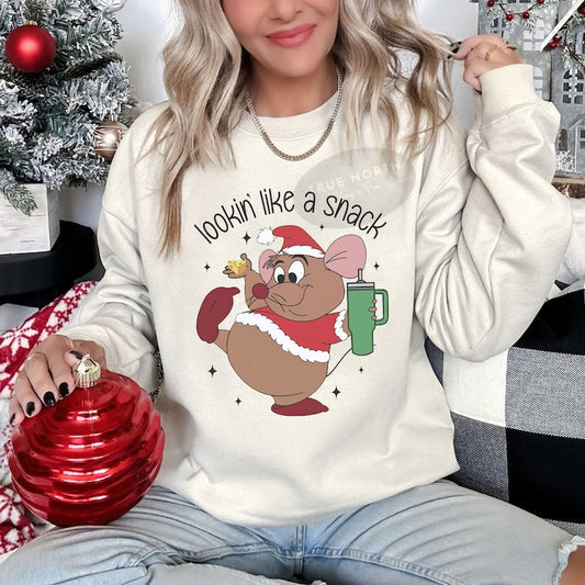 a woman sitting on a couch wearing a christmas sweater