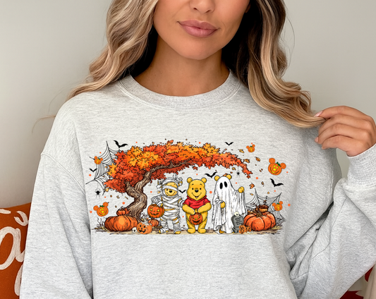 Person wearing a light gray sweatshirt with a Halloween-themed design featuring cartoon characters.