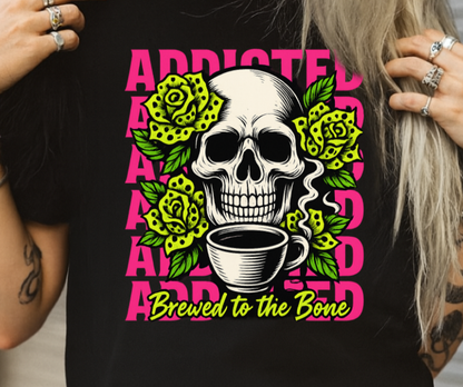Person wearing a black t-shirt with a skull and coffee design, text 'Addicted Brewed to the Bone'.