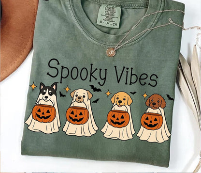 Green t-shirt with 'Spooky Vibes' and Halloween-themed dog illustrations on a white background.