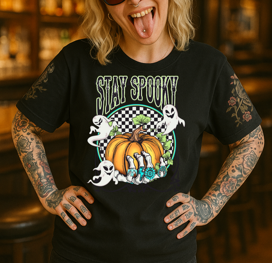 Person wearing a black t-shirt with a Halloween-themed design and a racing cap in a bar setting.
