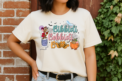 Person wearing a white t-shirt with colorful graphics and text, standing against a brick wall with greenery.