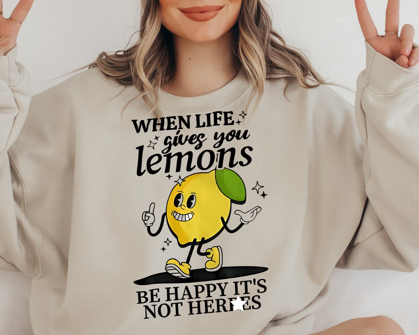 a woman wearing a sweatshirt that says when life gives you lemons be happy it