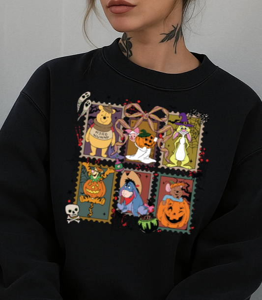 Person wearing a black sweatshirt with colorful patch designs sitting against a plain background