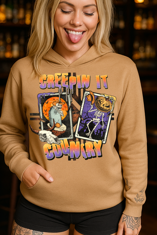 Woman wearing a tan hoodie with graphic designs and text in a bar setting