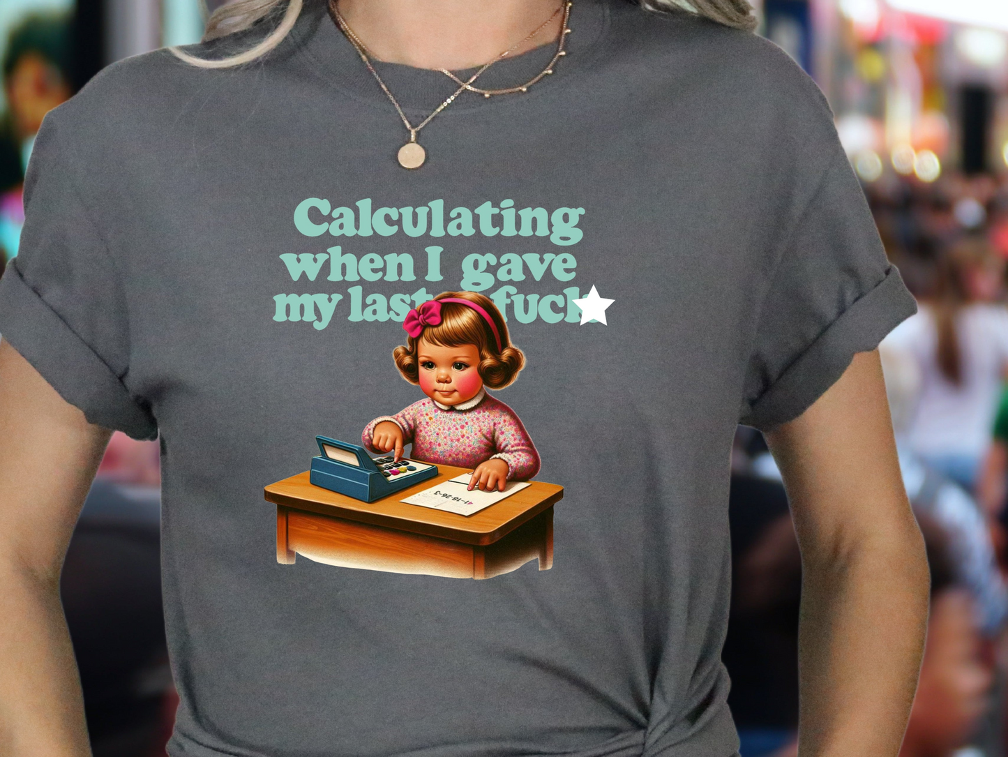 a woman wearing a t - shirt with a picture of a girl at a desk