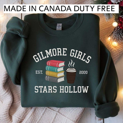 A dark green sweatshirt with a graphic design featuring a stack of books and a cup of coffee, along with text that reads "GILMORE GIRLS EST. 2000 STARS HOLLOW".