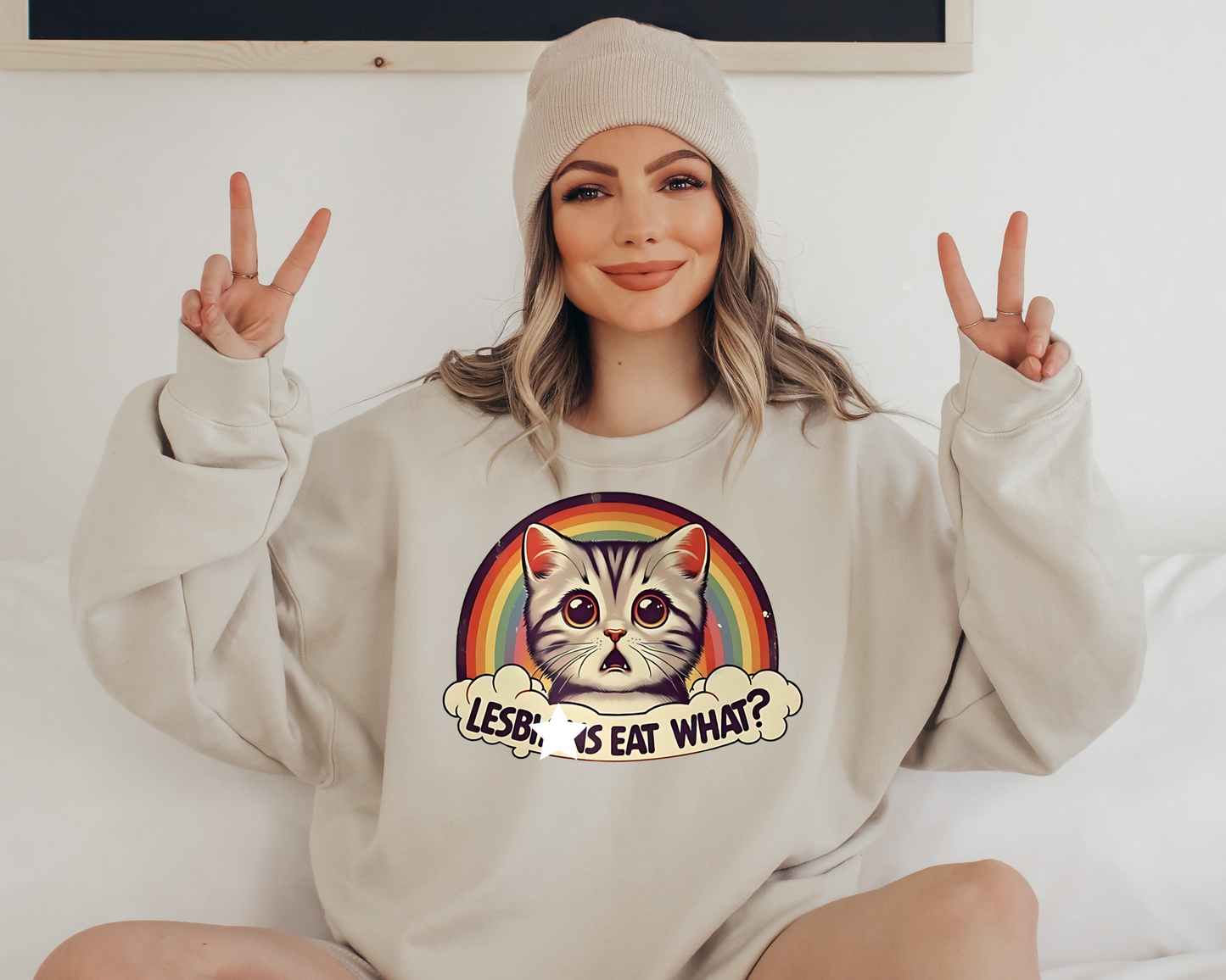 a woman sitting on a bed wearing a sweatshirt with a cat on it