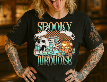 Person wearing a black t-shirt with 'Spooky Turquoise' design and a racing cap in a bar setting.