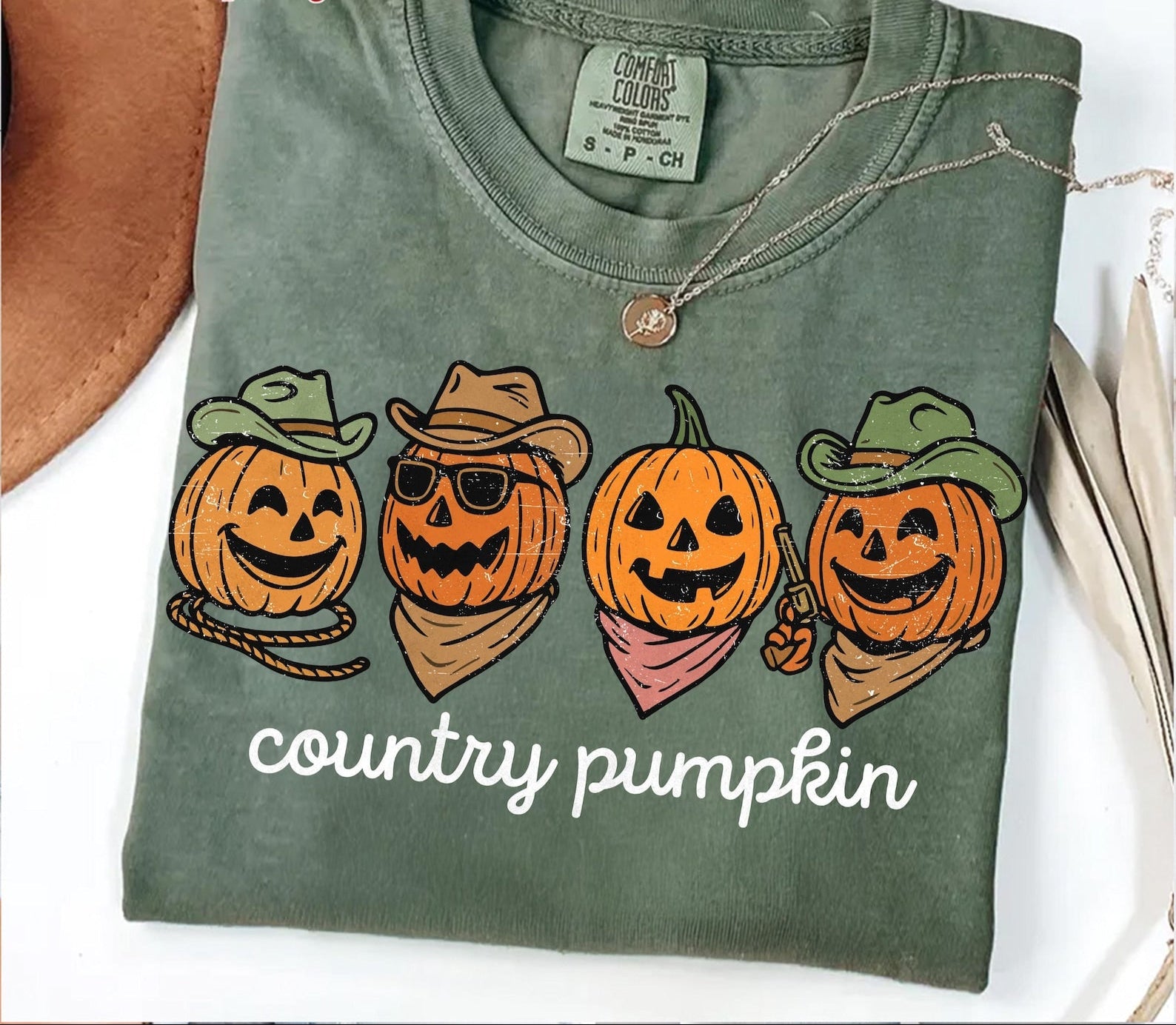 Green t-shirt with 'country pumpkin' design featuring pumpkins wearing hats and bandanas on a white background.
