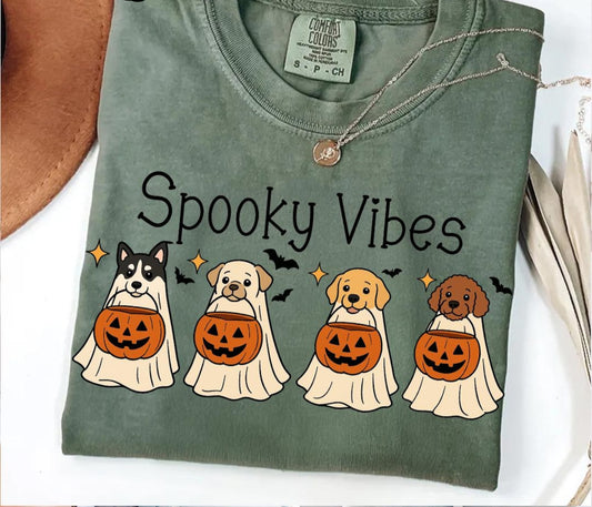 Green t-shirt with 'Spooky Vibes' and Halloween-themed dog illustrations on a white background.