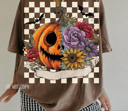 Brown t-shirt with a Halloween-themed design featuring a pumpkin, flowers, and checkered border.