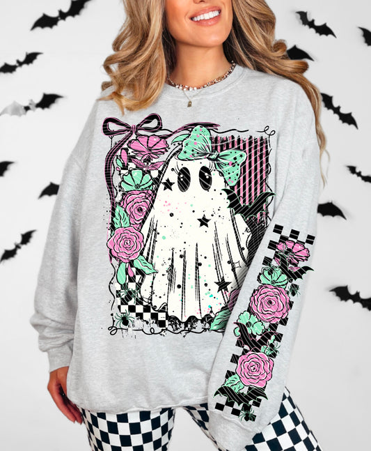 Person wearing a gray sweatshirt with a graphic design of a ghost, roses, and checkered patterns on a white background with black bats.