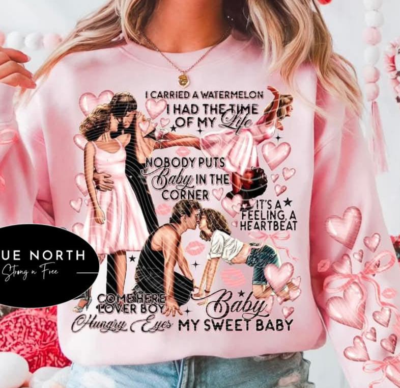 A pink sweatshirt with a printed text and illustrations related to the phrase 'I carried a watermelon had the time of my life', featuring characters in love and celebration.