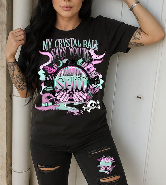 Woman wearing a black t-shirt with colorful graphic design against a wooden wall.