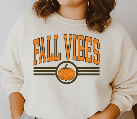 Woman wearing a 'Fall Vibes' sweatshirt with a pumpkin graphic against a plain background