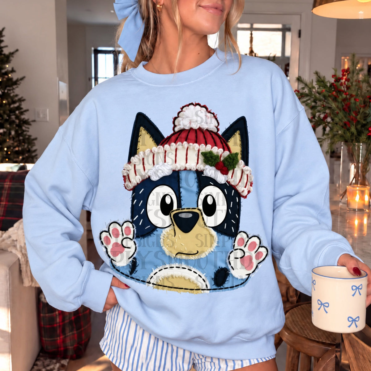 A cheerful blue puppy wearing a red and white winter hat with holly, with raised paws in a faux stitched fabric style.