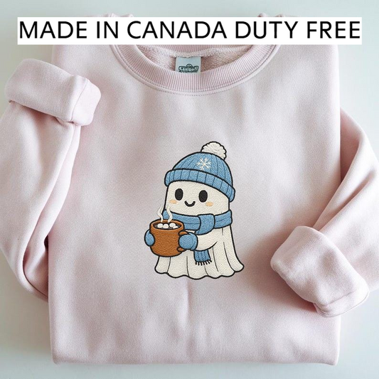 A pink sweater with a cartoon ghost character wearing a blue hat and scarf, holding a mug of hot chocolate, and the text "MADE IN CANADA DUTY FREE" above the sweater.