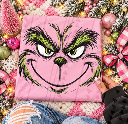 Grinch mischievous face DTF transfer shown on a pink garment