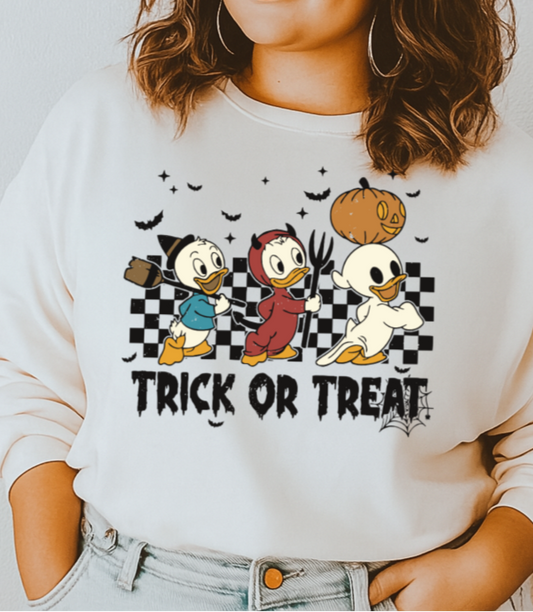 Woman wearing a white sweatshirt with cartoon characters and 'Trick or Treat' text.