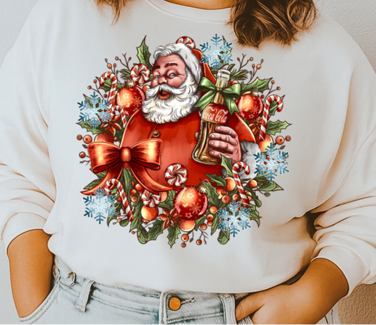 Woman wearing a white sweatshirt with a festive design of Santa Claus holding a beer.