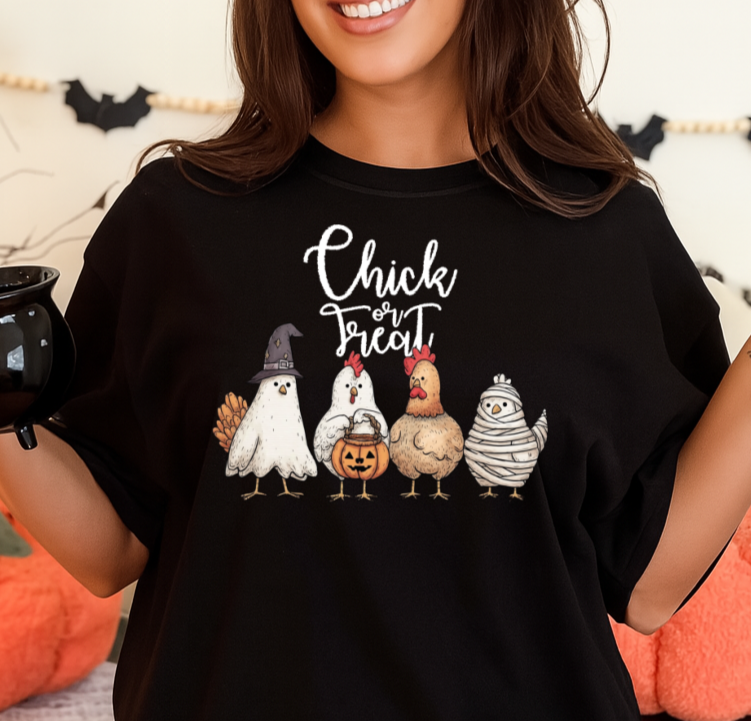 Person wearing a black t-shirt with Halloween-themed design, holding a mug in a decorated room.