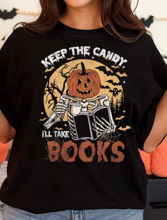 Person wearing a black t-shirt with Halloween-themed design, holding a mug in a festive setting.