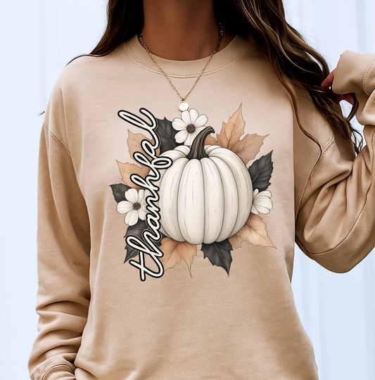 Beige sweatshirt with a pumpkin and 'Thankful' design on a white background