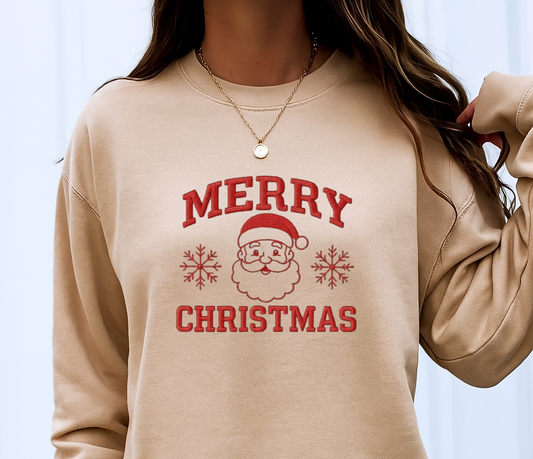Beige sweatshirt with 'Merry Christmas' print worn by a person on a light blue background