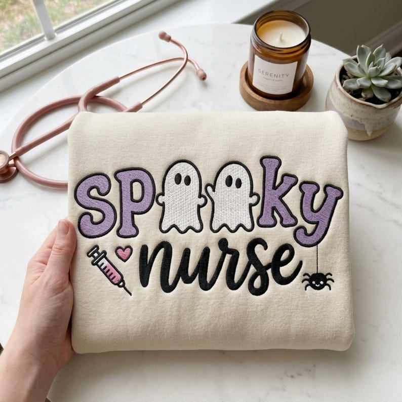 Close view of the Spooky Nurse embroidery on a finished cream sweatshirt