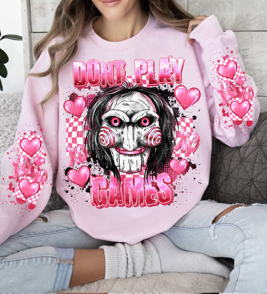 a woman sitting on a couch wearing a pink sweatshirt