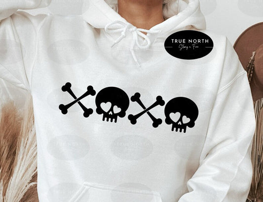 a person wearing a white hoodie with a skull and crossbones on it