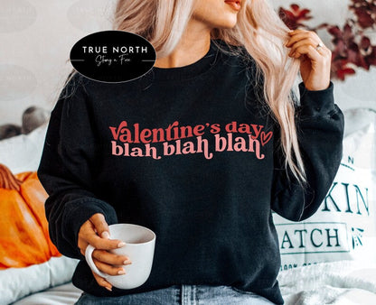 a woman wearing a valentine's day sweatshirt holding a cup of coffee