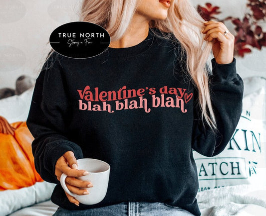 a woman wearing a valentine's day sweatshirt holding a cup of coffee