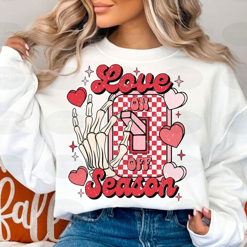 a woman wearing a white sweatshirt that says love is in the air