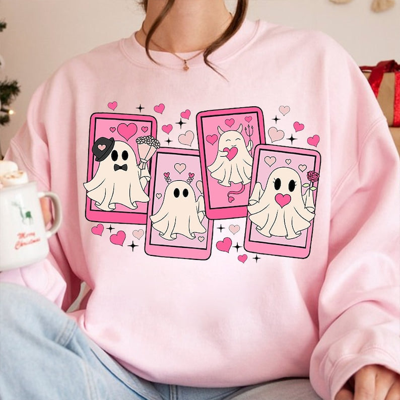 a woman wearing a pink sweater with ghost pictures on it