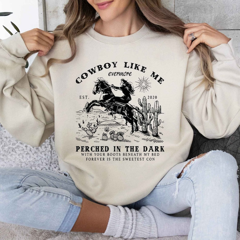 a woman wearing a cowboy like me sweatshirt