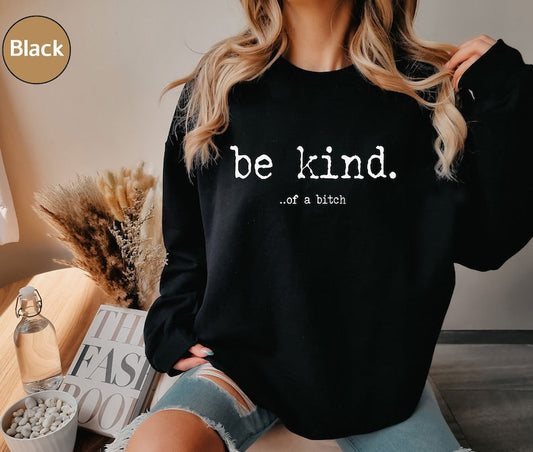a woman wearing a black sweatshirt that says be kind of a bitch